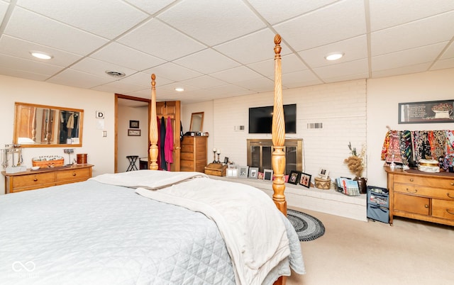 carpeted bedroom with a drop ceiling