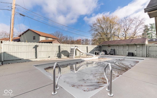 view of swimming pool with a water slide and a patio