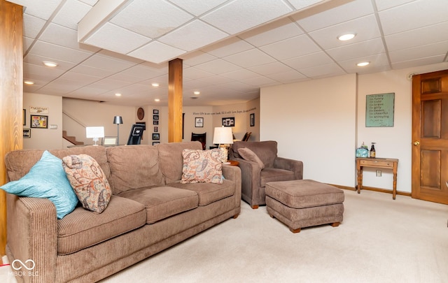 carpeted living room with a drop ceiling