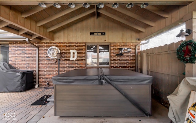 deck featuring a patio area and a hot tub