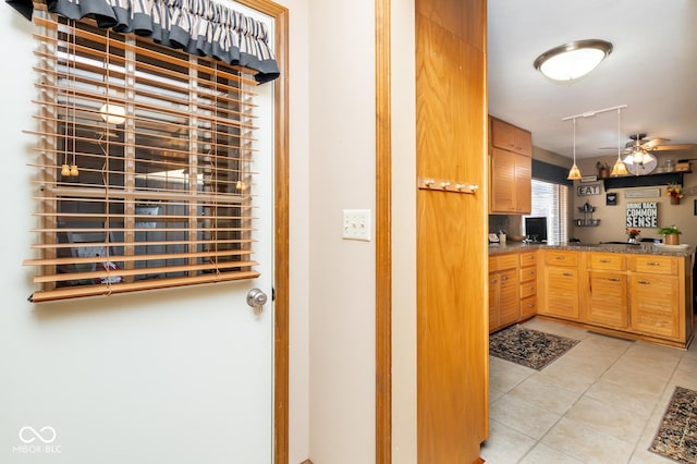 interior space with ceiling fan, light tile patterned flooring, and rail lighting