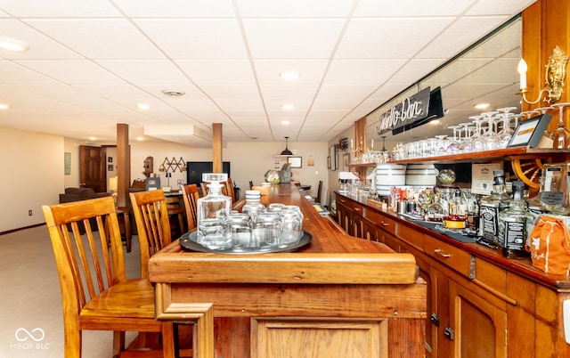 bar featuring carpet floors and a drop ceiling