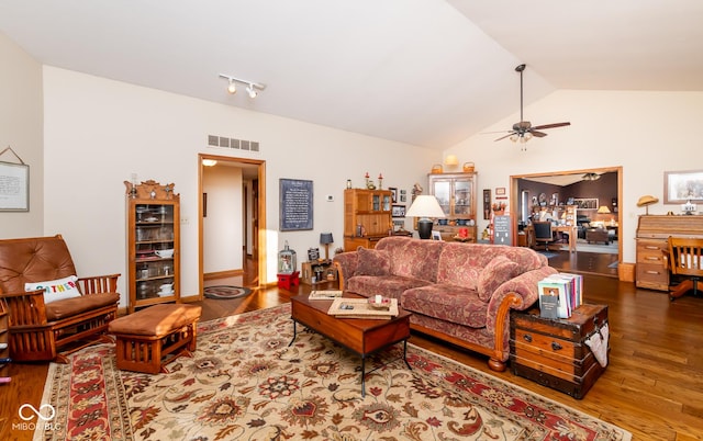 living room featuring lofted ceiling, ceiling fan, and dark hardwood / wood-style floors