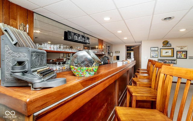 bar with wooden counters and a paneled ceiling