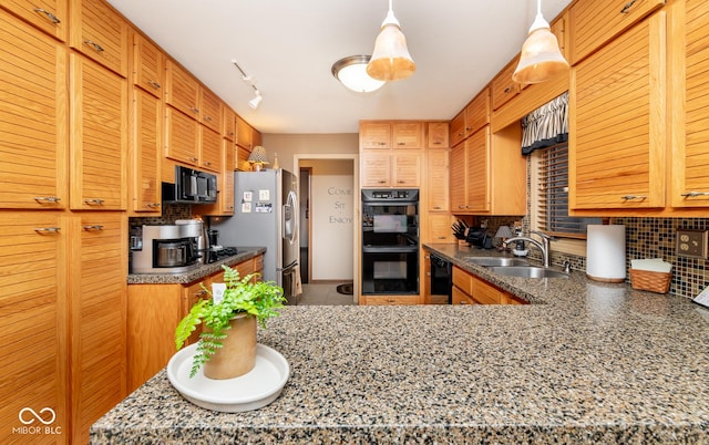 kitchen featuring black appliances, track lighting, pendant lighting, sink, and tasteful backsplash