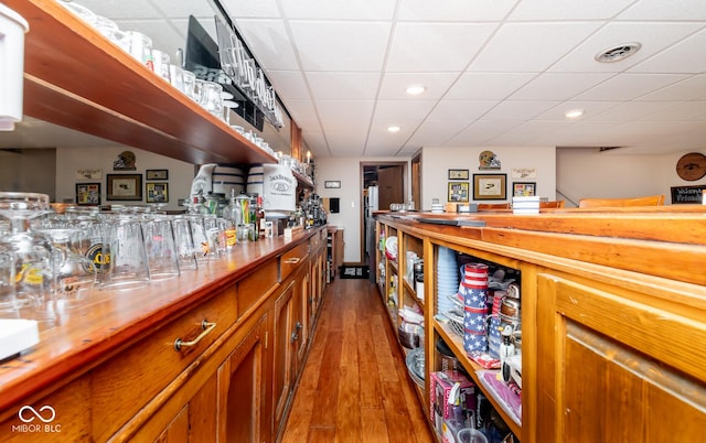 bar with a paneled ceiling and wood-type flooring