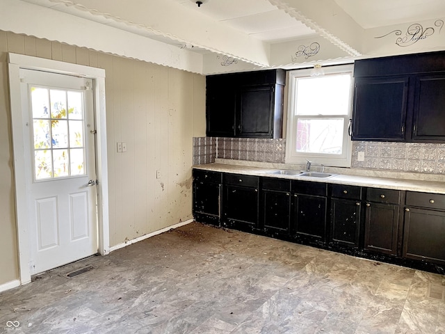 kitchen featuring sink, backsplash, beamed ceiling, and plenty of natural light