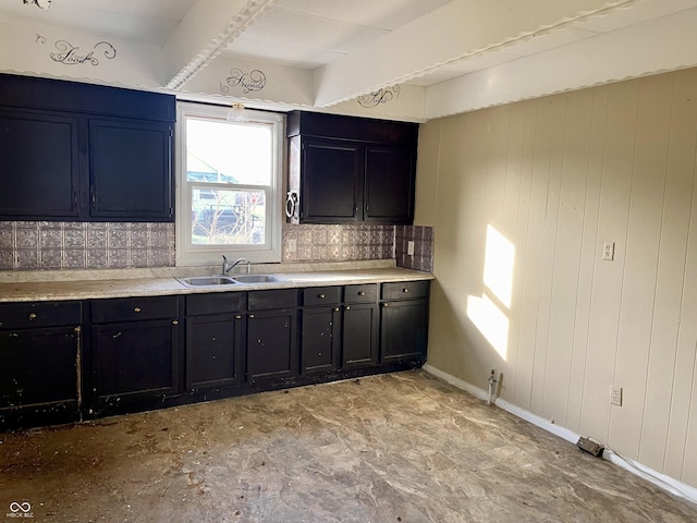 kitchen featuring sink and wood walls