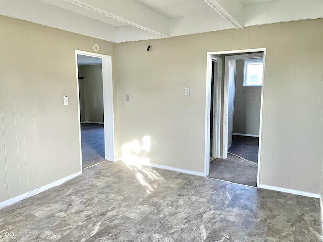 spare room featuring wooden walls