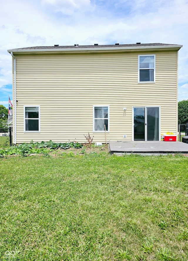 back of house with a wooden deck and a yard