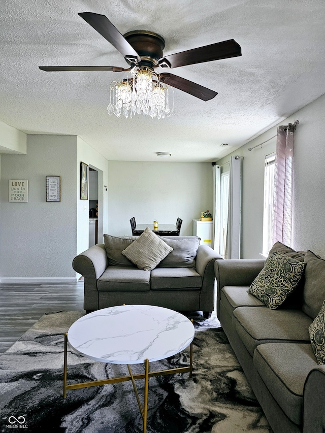 living room with ceiling fan, dark hardwood / wood-style flooring, and a textured ceiling