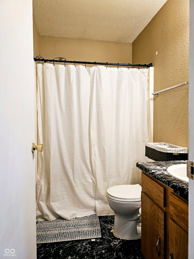 bathroom with vanity, a textured ceiling, and toilet