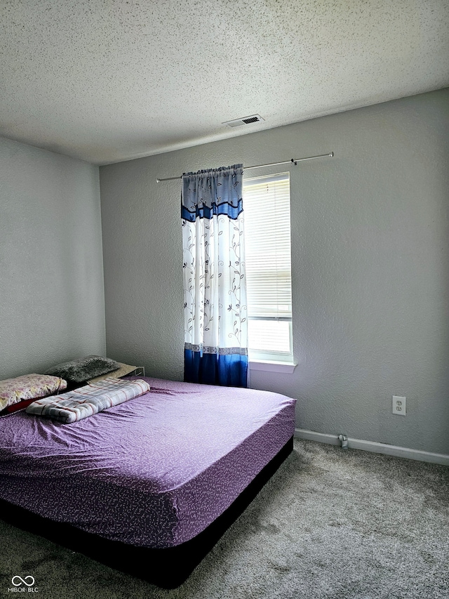 bedroom with carpet flooring and a textured ceiling