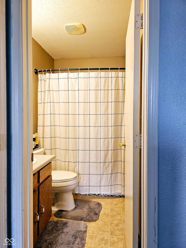 bathroom featuring tile patterned floors, vanity, a textured ceiling, and toilet