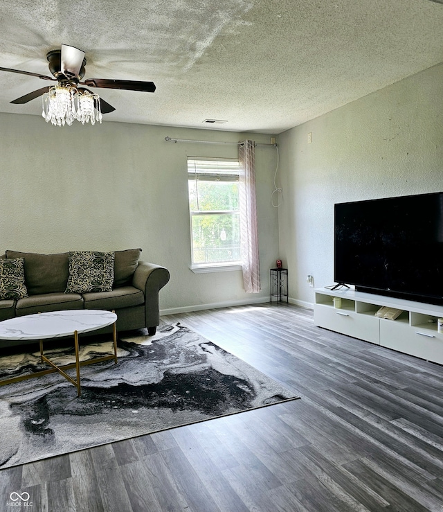 living room featuring hardwood / wood-style flooring, ceiling fan, and a textured ceiling