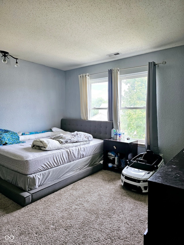 bedroom featuring carpet and a textured ceiling