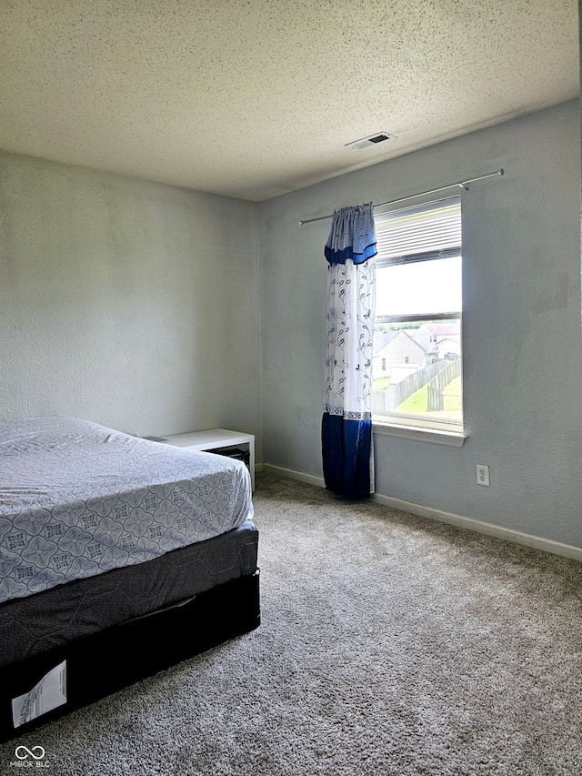 carpeted bedroom with a textured ceiling