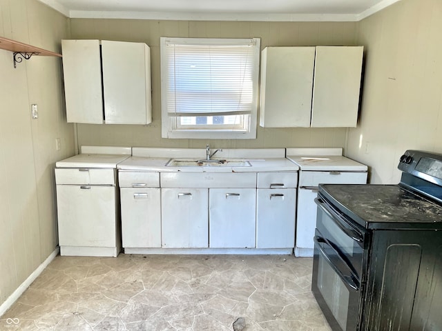 kitchen with white cabinetry, sink, range with two ovens, and wood walls