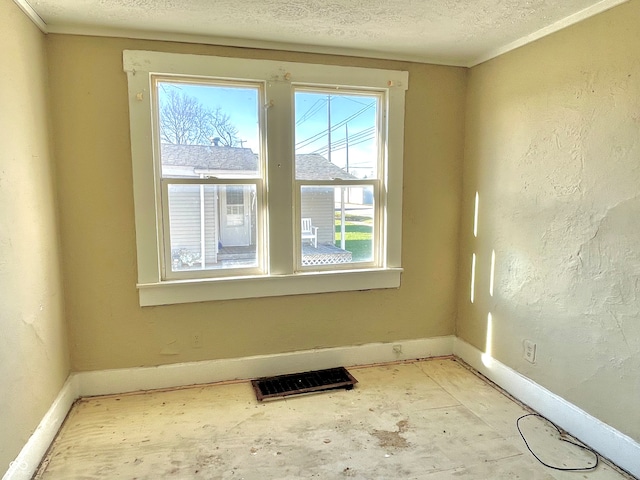 unfurnished room featuring a textured ceiling and ornamental molding