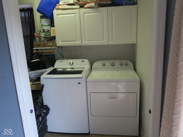 laundry room featuring washer and dryer and cabinets