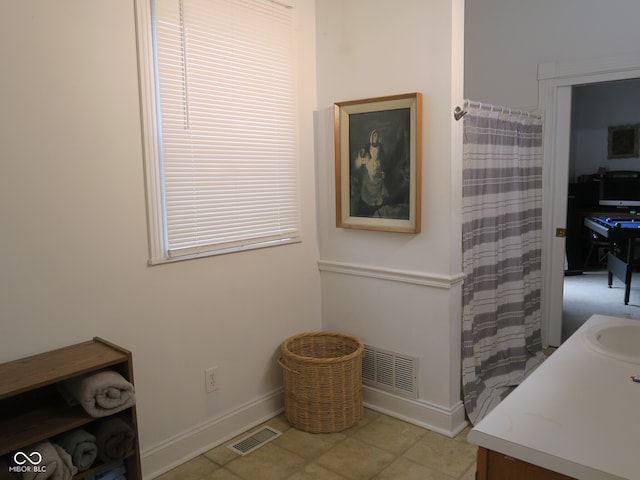 interior space with tile patterned flooring, vanity, and a shower with curtain