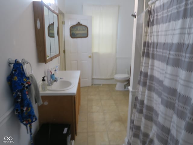 bathroom featuring a shower with curtain, toilet, and vanity