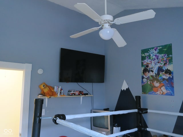 workout room featuring ceiling fan and vaulted ceiling