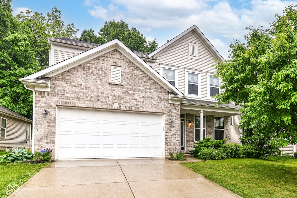 5171 Alpine Violet Way, Indianapolis, IN 46254 - traditional-style home featuring brick siding, driveway, a front yard, and an attached garage