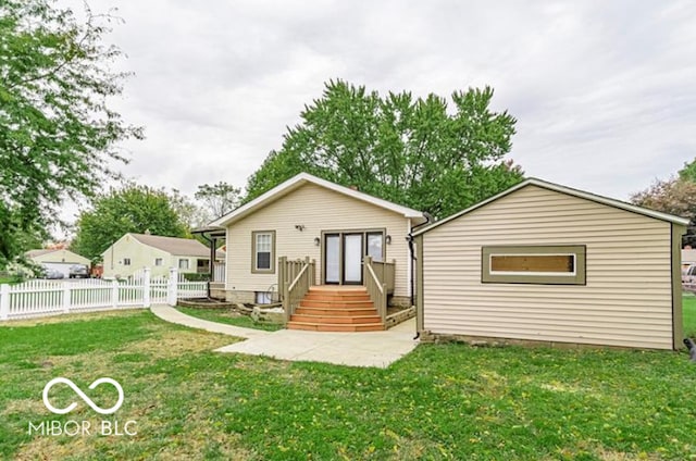 rear view of property featuring a lawn