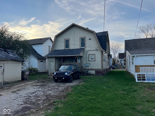 back house at dusk with a lawn