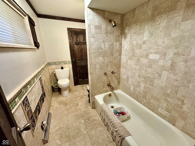 bathroom featuring crown molding, tiled shower / bath combo, tile walls, and toilet