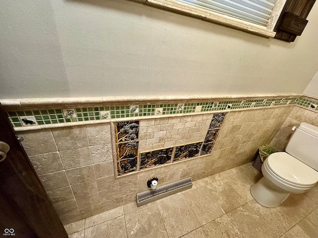 bathroom with toilet and tile walls