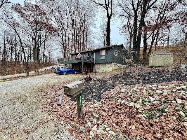 view of front facade featuring a storage unit and a wooden deck