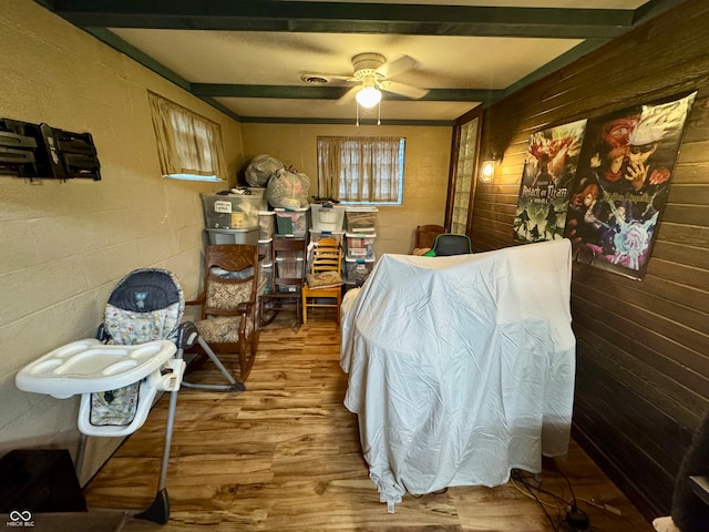 bedroom featuring hardwood / wood-style floors, ceiling fan, and beam ceiling