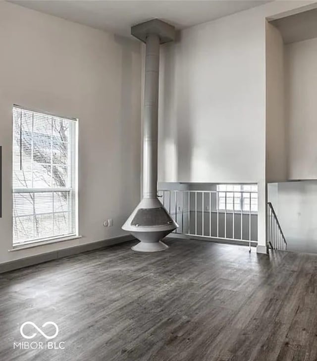 unfurnished living room with dark hardwood / wood-style flooring and a wood stove