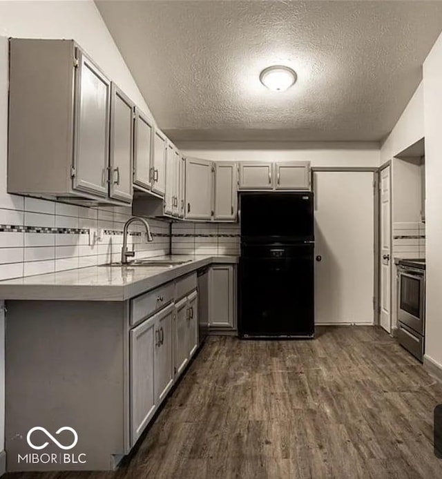 kitchen with dark hardwood / wood-style flooring, stainless steel appliances, gray cabinets, and sink