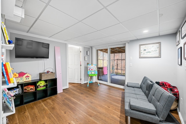 living room featuring a drop ceiling and wood-type flooring