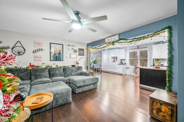 living room with ceiling fan and dark wood-type flooring