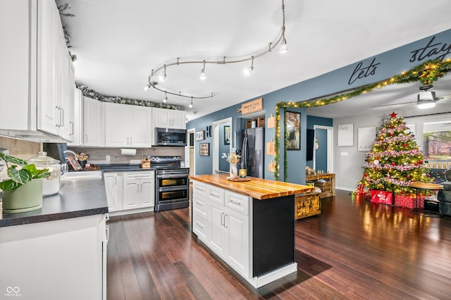 kitchen with white cabinets, sink, appliances with stainless steel finishes, tasteful backsplash, and butcher block countertops