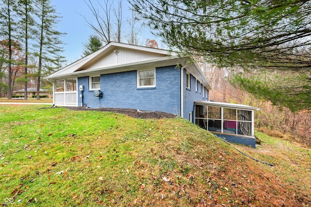 back of property featuring a lawn and a sunroom