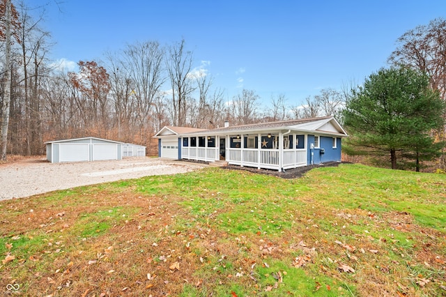 view of front facade with a porch, a garage, an outdoor structure, and a front yard