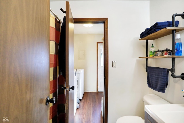 bathroom featuring hardwood / wood-style floors, vanity, independent washer and dryer, and toilet