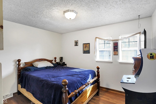 bedroom with dark hardwood / wood-style flooring and a textured ceiling