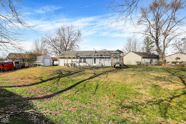 back of house featuring a storage shed and a lawn