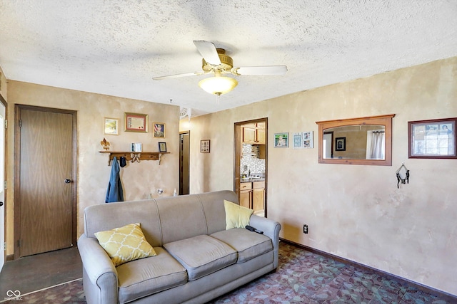 living room featuring a textured ceiling, ceiling fan, and sink