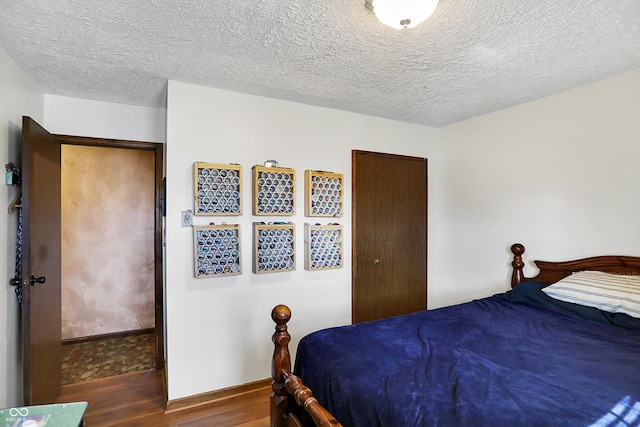 bedroom featuring dark wood-type flooring and a textured ceiling