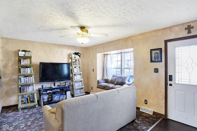 living room featuring a textured ceiling and ceiling fan