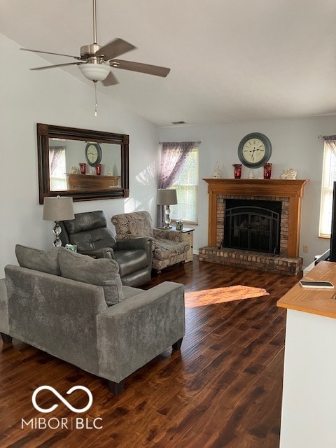 living room featuring dark hardwood / wood-style flooring, a brick fireplace, ceiling fan, and vaulted ceiling