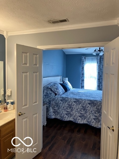 bedroom featuring sink, crown molding, dark wood-type flooring, and a textured ceiling