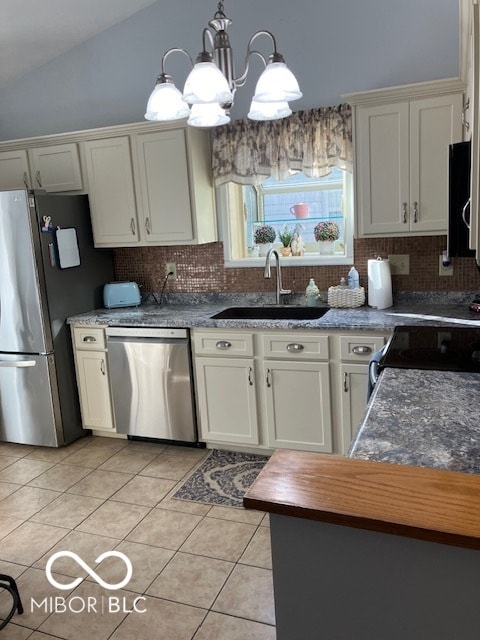 kitchen with pendant lighting, lofted ceiling, sink, stainless steel appliances, and a chandelier